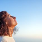 Young,Woman,Breathing,Fresh,Air,With,Closed,Eyes,And,Serene