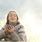 Satisfied,Woman,Drinking,And,Relaxing,In,Winter,Closing,Ayes,In