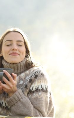 Satisfied,Woman,Drinking,And,Relaxing,In,Winter,Closing,Ayes,In