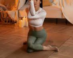 iemand die thuis yoga doet op een mat met kaarslicht of lampjes iemand die thuis yoga doet op een mat met kaarslicht of lampjes