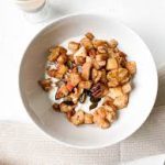 schaaltje met noten, appel en een beker yoghurt